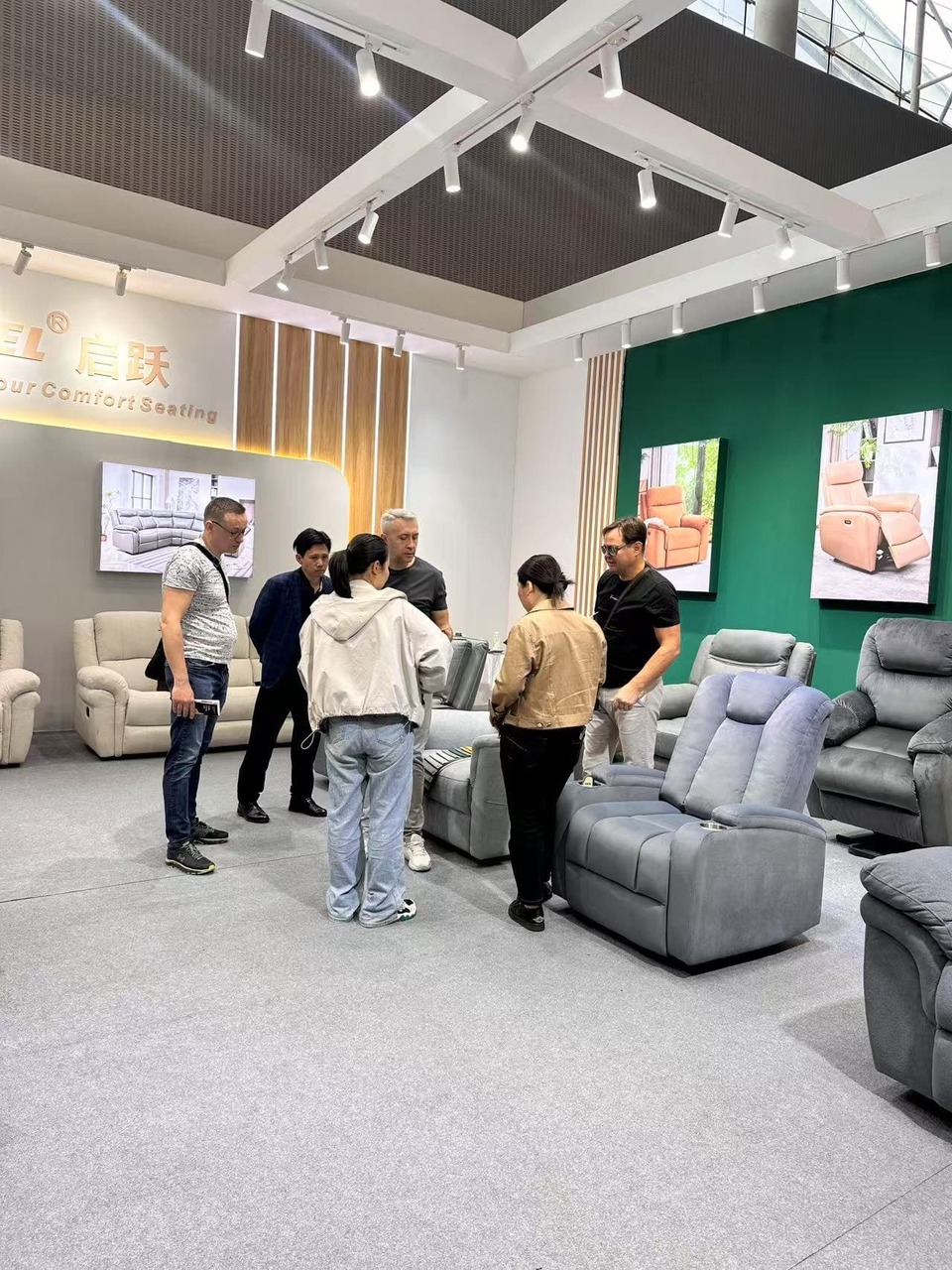 Käufer diskutieren über Relaxsofas am Stand von Qiyue
