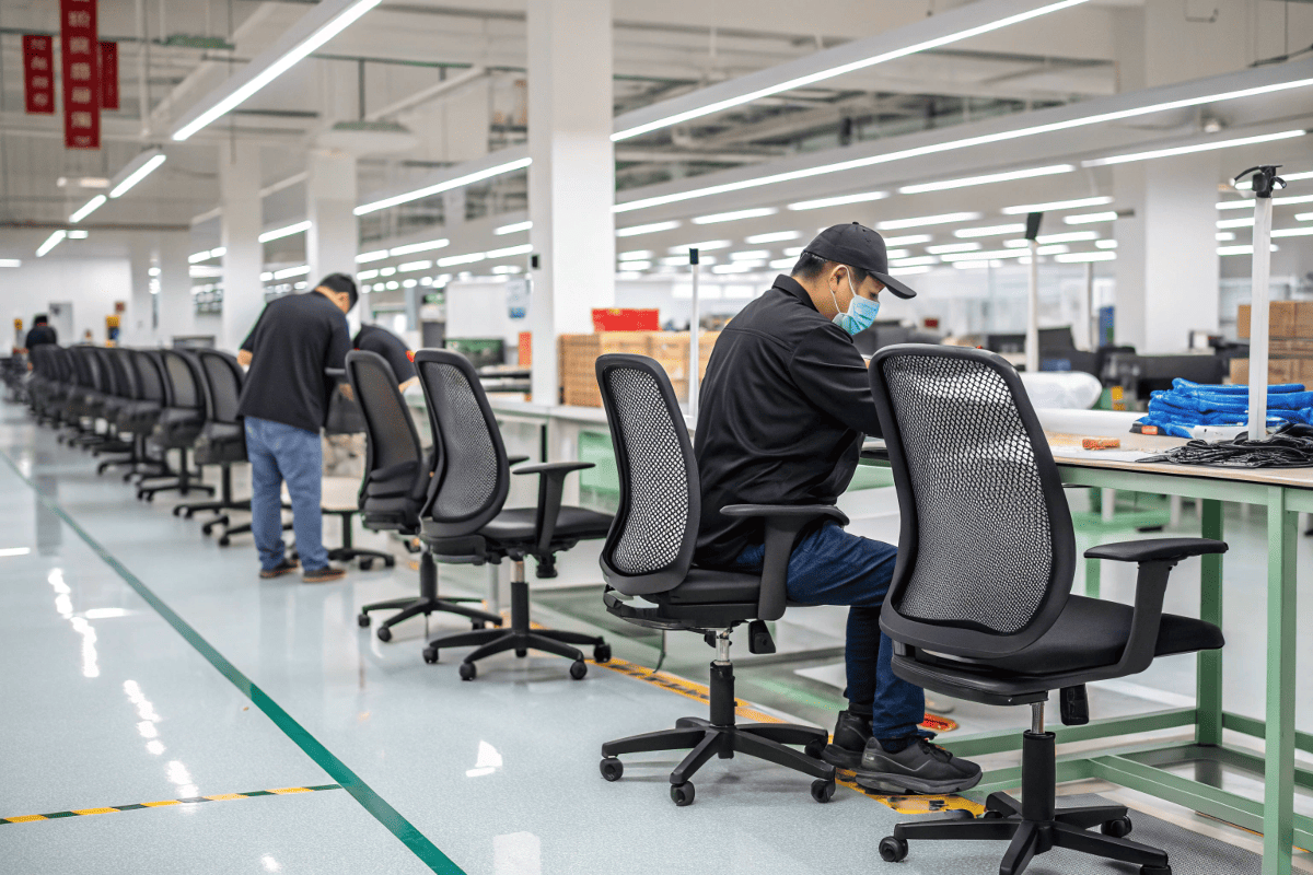 factory workers assembling mesh office chairs